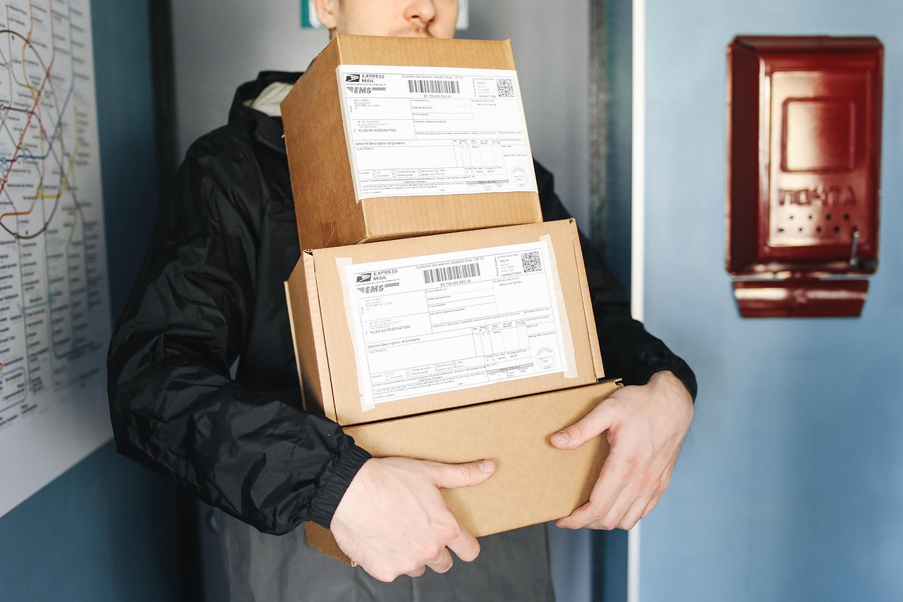 Entregador carregando pilha de caixas de encomendas — a comissão do afiliado Shopee só é confirmada depois que o pedido é entregue