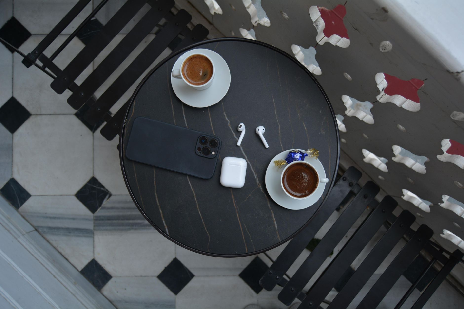 Xícara de café ao lado de um celular sobre a mesa pela manhã, representando o primeiro pico de acesso do dia
